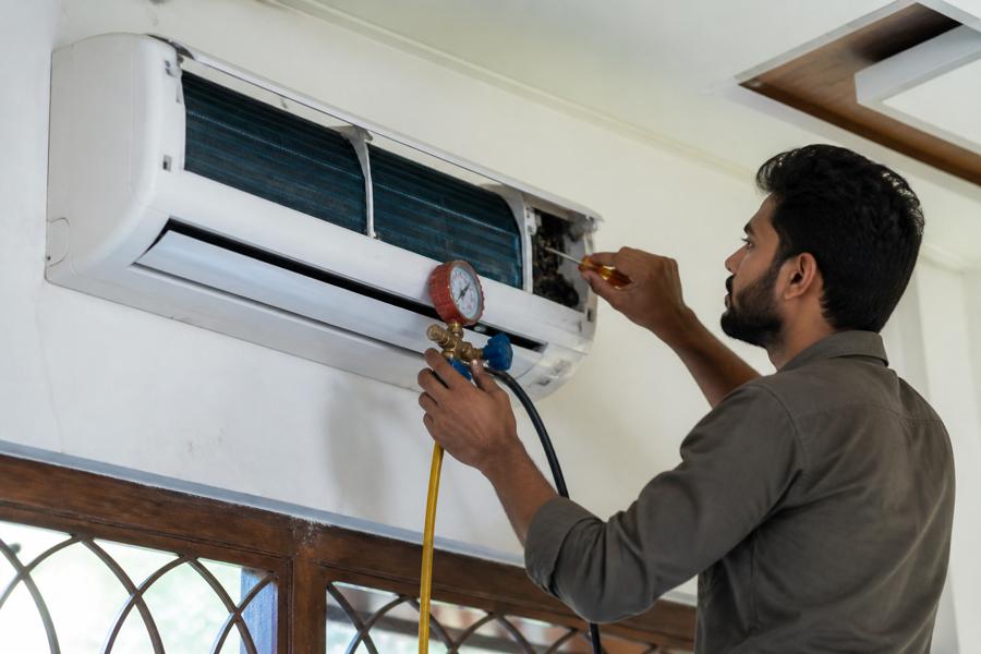 Technician servicing a split air conditioner